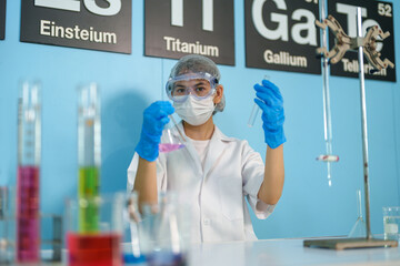 Modern medical research laboratories Beautiful female scientist wearing protective goggles mixes chemicals in test tubes in laboratory biochemical samples, an advanced science laboratory for medicine.