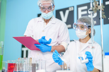 Modern medical research laboratories Beautiful female scientist wearing protective goggles mixes chemicals in test tubes in laboratory biochemical samples, an advanced science laboratory for medicine.