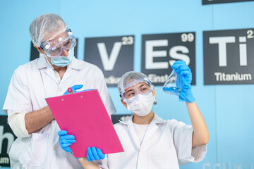 Modern Medical Research Laboratory: Two scientists work together to analyze chemicals in lab flasks...