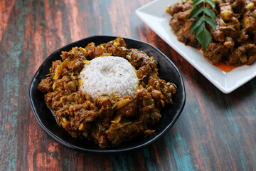 Rice Puttu or pittu steamed rice cake and meet beef curry popular in South Indian states of Kerala, Tamil Nadu, Karnataka,  Sri Lanka.	