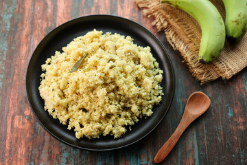 Upma, Uppittu green banana and Kadala curry Kerala breakfast food on dark black background Tamil Nadu South India. Made with Rava or semolina.	