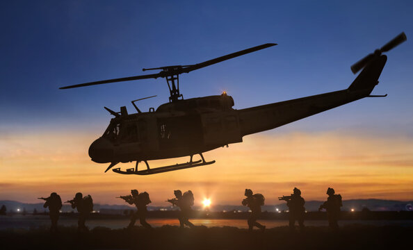 Military special forces helicopter drops operation at sunset