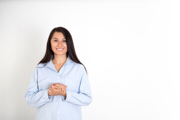 Portrait of a beautiful brunette woman in a blue shirt on a white background. Neutral makeup. Space for text