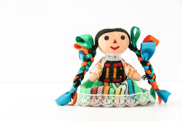 Obraz na płótnie Canvas Tradicional mexican doll in a colorful dress of Mexico from Queretaro, hand crafted, front view - Muñeca mexicana