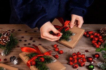 The girl decorates Christmas gifts. Celebrating Christmas and New Years.