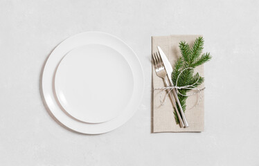 Christmas table setting on gray background. Empty white plate for design. View from above. Space...