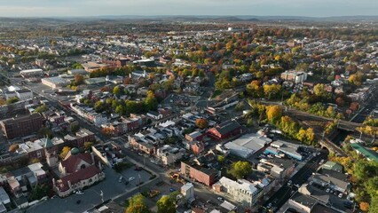 Magic hour light in American city. Colorful fall leaves on trees among residential urban downtown setting.