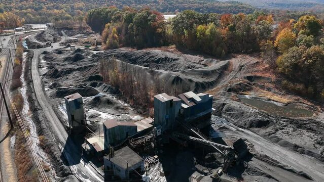 Aerial of American coal plant. Mining operation in USA. Aerial of land environmental damage. Autumn fall season foliage.