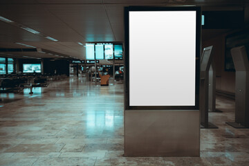 A mockup of an empty advertising banner placeholder in a waiting room of an airport terminal with a copy space area on the left; a blank template of an indoor billboard in a hall of a train station