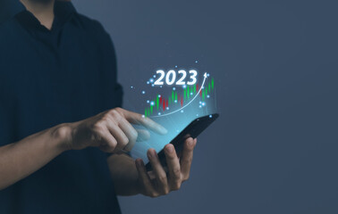 Businessman plans an effective analytical strategy showing a 2023 stock chart positive digital technology.