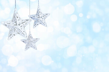 star shaped christmas decorations on blue background with copy space