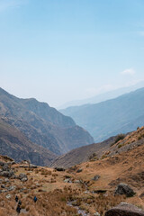 Fototapeta premium Cuatro personas en un páramo caminado por un sendero hacia la montaña, y el cielo con neblina, en los andes de PERÚ Sudamérica 