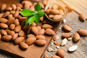 Almonds nuts on wooden background white green leaf , Delicious sweet almonds on the table, roasted almond nut for healthy food and snack