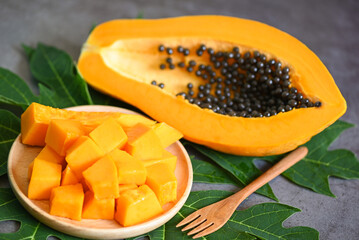 papaya fruits on dark backgroud, fresh ripe papaya slice cut in half tropical fruit with papaya seed and leaf leaves from papaya tree