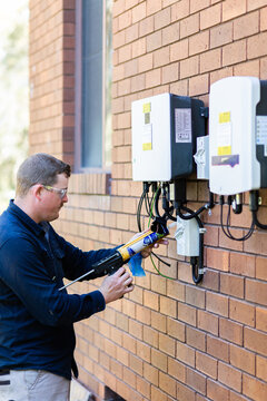 Electrician Using Silicone Glue Gun To Make Electrical Wiring Into House Weatherproof