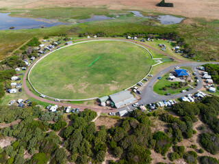 Aerial view of caravans parked around a sporting oval in a rural setting