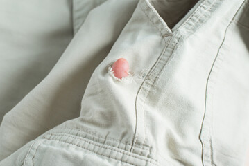 Damaged clothes, the buyer's hand checking the material and showing a finger in the hole, close-up