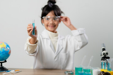 education, science, chemistry and children concept - kids or students with test tube making experiment at school laboratory