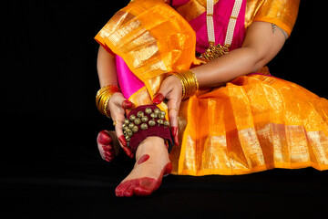 Bharatanatyam Indian classical dancer feet in close up view wearing ghungroo with traditional...
