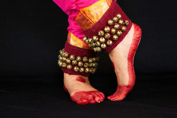 Indian classical dancer legs in closeup view demonstrating dance mudra or gestures.