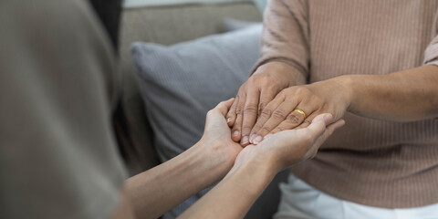 people, age, family, care and support concept - close up of senior and young woman holding hands