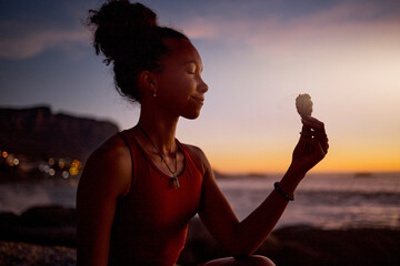 Beach meditation, sunset and yoga woman with sage aromatherapy smoke for aura, soul or chakra energy healing. Zen mindset, pilates mindfulness and black girl meditate for twilight spiritual balance