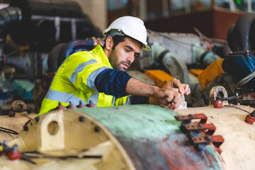 professional technician engineer working to check safety system of heavy industry manufacturing machine in construction plant and service a factory equipment of production job technology