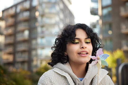 Teenage girl blowing on pinwheel