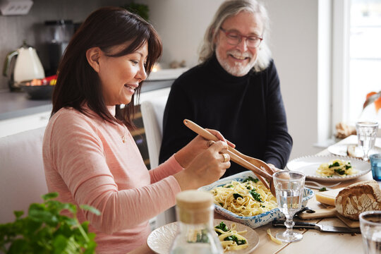 Man And Woman Eating Dinner At Home Together