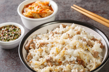 Kongnamul Bap is a classic Korean rice cooked with soybean sprouts with yummy seasoned soy sauce and kimchi closeup on the table. Horizontal