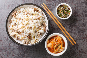 Korean food kongnamul bap rice with soy sprouts and meat served with Yangnyumjang sauce and kimchi close-up on the table. Horizontal top view from above