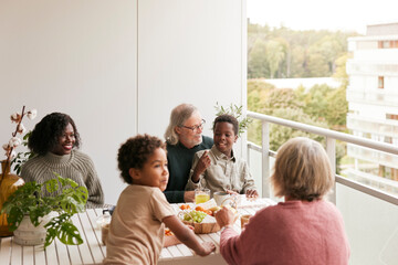 Family sitting at table on balcony