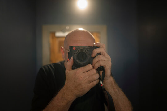 bold man with a leica camera in mirror