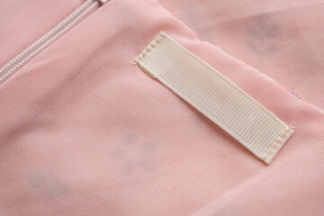 Blank laundry care clothes label on fabric texture background