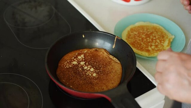 Process of frying homemade pancakes on frying pan close up with selective focus. Maslenitsa, spring festival concept. Russian traditional food. Pancake week. Delicious breakfast