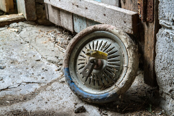 An old dirty wheel from a children's bike. A wheel from a bicycle in a rural barn. Selective focus.
