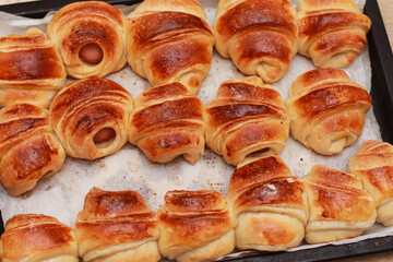 appetizing baked croissants with sausages close-up