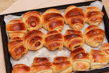 appetizing baked croissants with sausages close-up