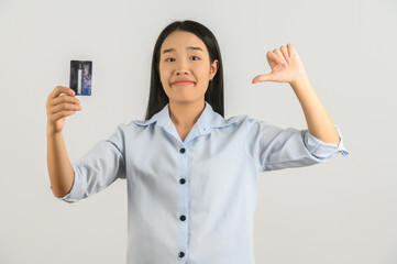 Portrait of positive young asian woman showing credit card good mood salary isolated on white background