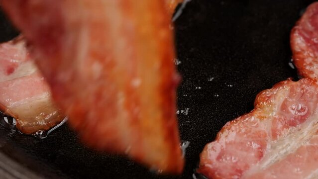 Bacon. Frying bacon in pan, close up. Traditional breakfast