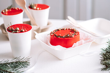 Takeaway Christmas cake in white disposable cups and bento cake on white table.