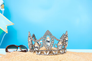 Desert Sand Ocean wind Diamond Crown put into Deep blue sky nature hot tropical island for Miss Beauty Pageant Contest Competition, bikini sash high heel shoes hang on outing trip camping background © Jade
