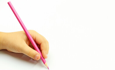 Left, or left-handed, of child holding a pink pencil or paint