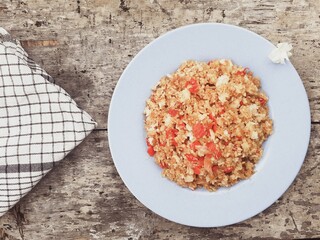 Close up special Asian breakfast on a plate. Menu with red chili, onion, salt and soy sauce. Wooden background. Top view.