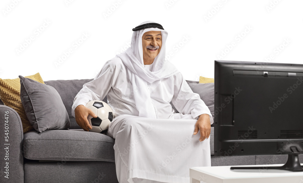 Sticker arab man in a robe holding a ball and watching football on tv