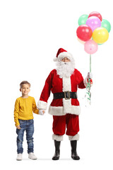 Full length portrait of santa claus with a bunch of balloons holding hands with a little boy