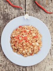 Close up special Asian breakfast on a plate. Menu with red chili, onion, salt and soy sauce. Wooden background. Top view.