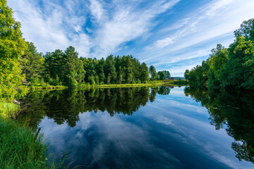 Beautiful summer view from the shore of a calm and shiny river