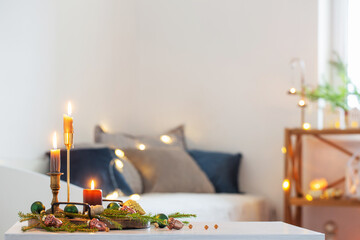 burning candles with christmas decor in white cozy interior