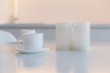 Close-up of coffee cup on table at direct sunlight. Morning coffee with steam in white cup